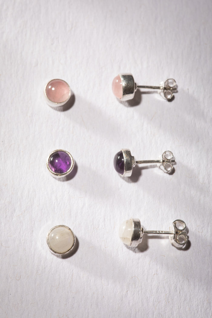 Gemstone earring stud trio in the theme of Goddess. The studs are Rainbow Moonstone, Rose Quartz, and Amethyst