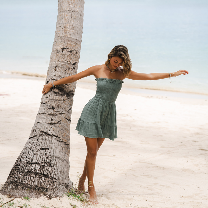 Sage Daiquiri Dress, worn arms out against palm tree