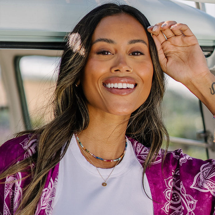 3mm Good Vibes + Heart Chakra Necklace Stack, worn smiling in van