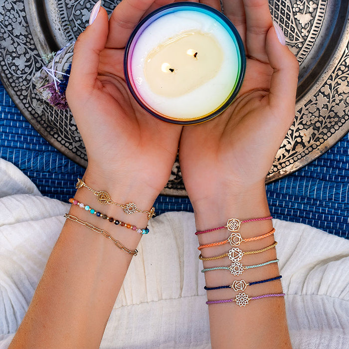 7 Chakras Bracelet, stacked on wrist with candle