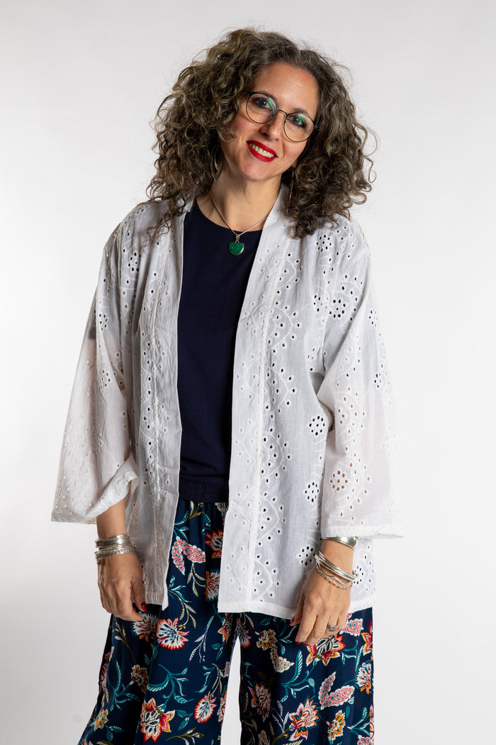 Susan is wearing the one size Anandi Eyelet Cardigan in White.
