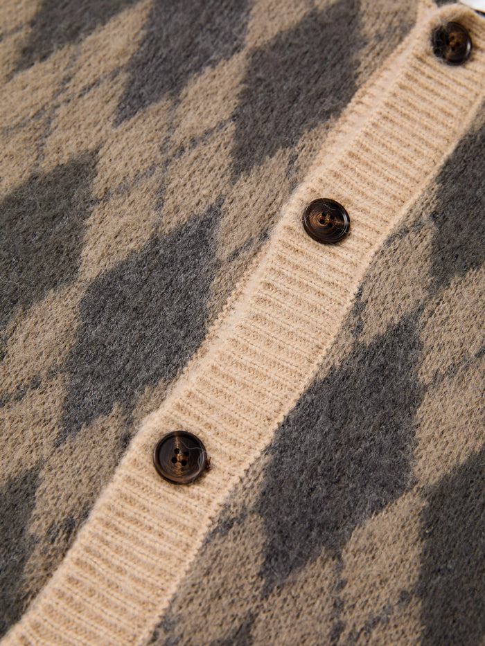 Close-up of the FOUND Argyle Cardigan, showcasing its beige and grey wool blend argyle pattern with dark buttons on a ribbed placket.