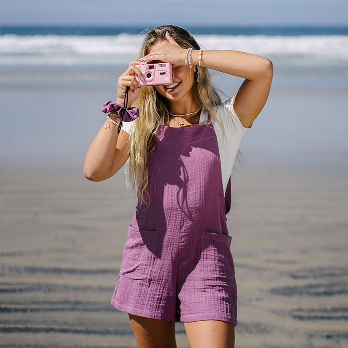 Berry Boardwalk Romper, worn on the beach with camera