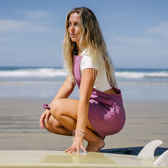 Berry Boardwalk Romper, worn crouching by surfboard