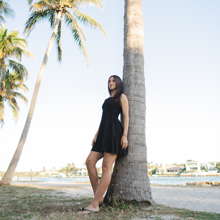 Black Daiquiri Dress with Adjustable Straps, worn by a palm tree