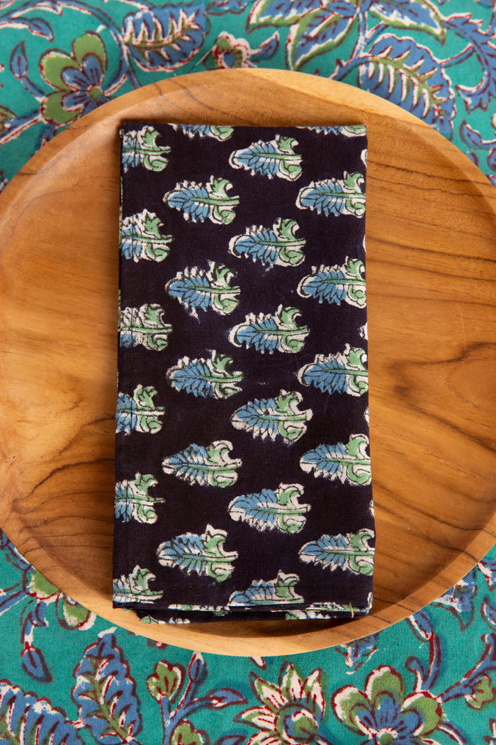 Black floral block print napkin on teak plate and block print placemat
