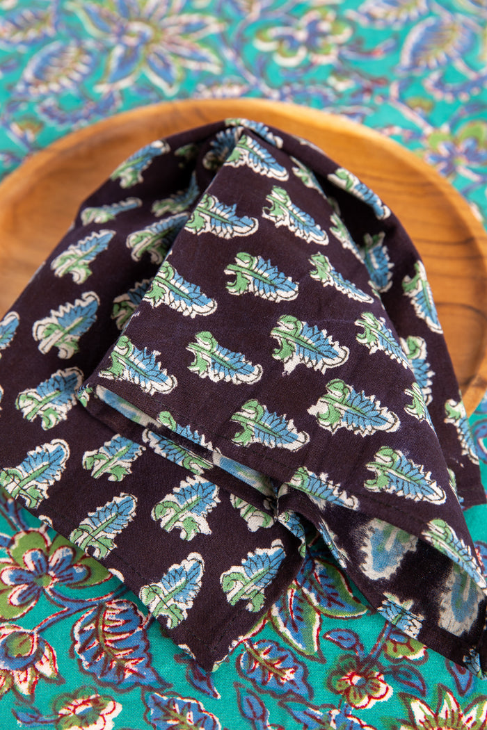 Black floral block print napkin on teak plate and block print placemat