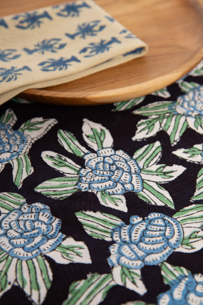 Black floral block print placemat under teak plate and block print napkin