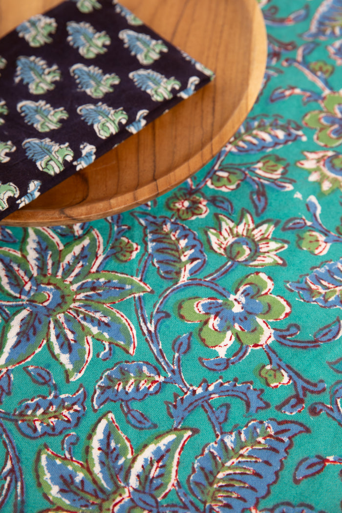 Turquoise floral block print placemat under teak plate and block print napkin