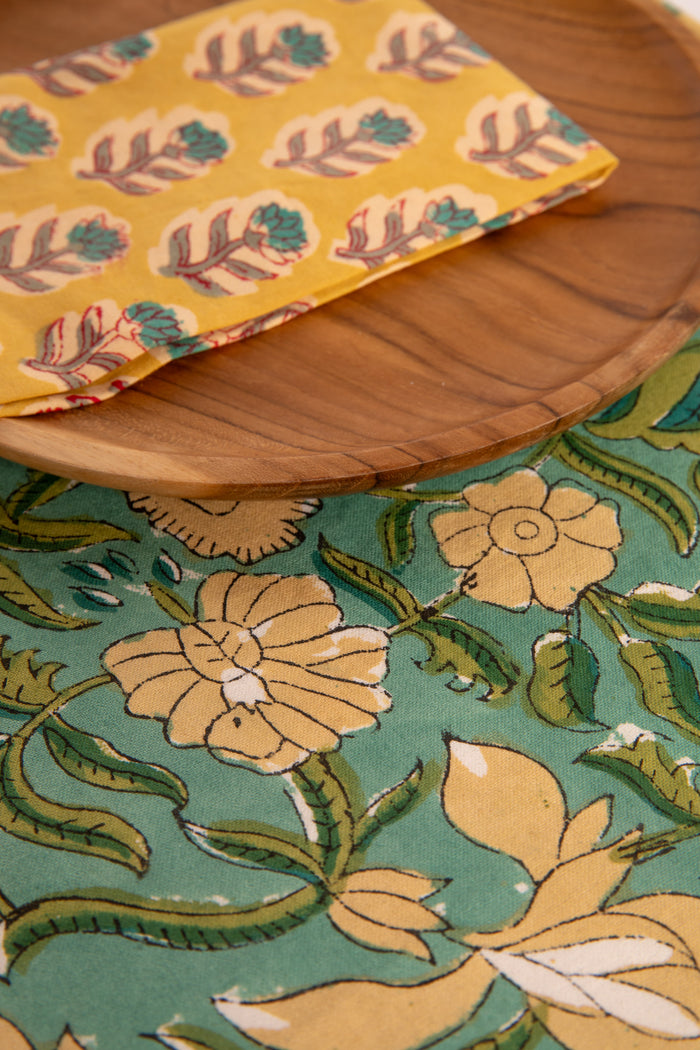 Aquamarine floral block print placemat under teak plate and block print napkin