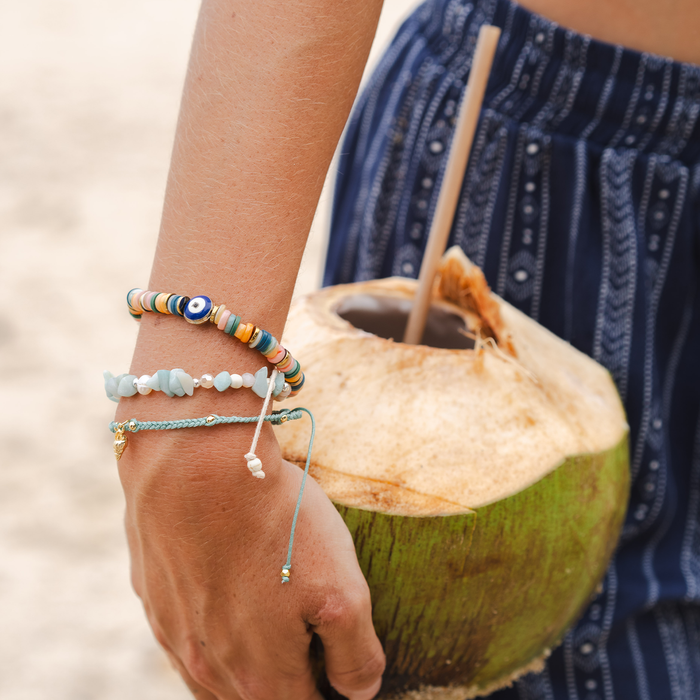 Blue Lagoon Seastone Bracelet, worn holding coconut drink