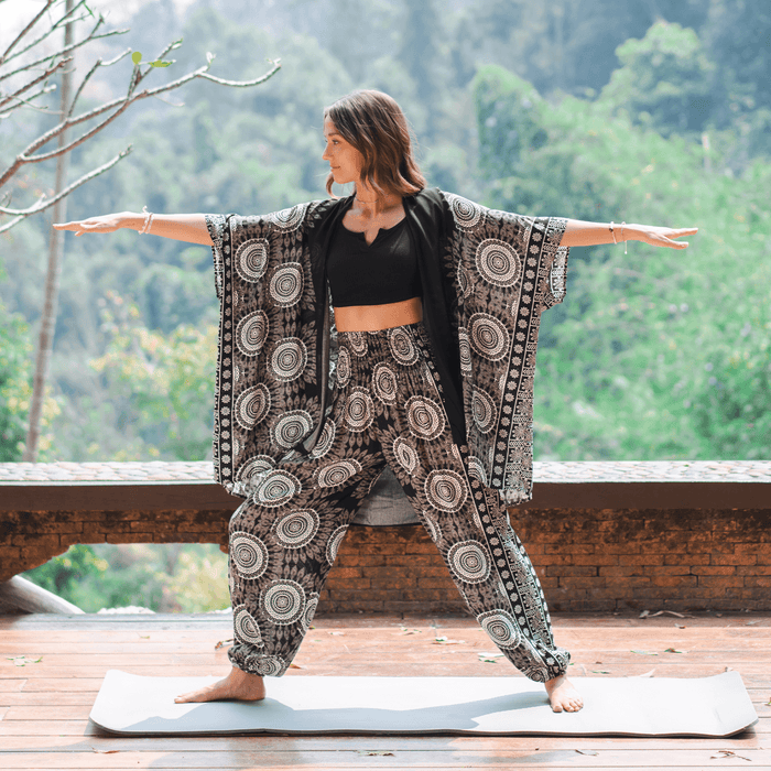 Model wearing a lounge set consisting of black and cream mandala print harem pants and a matching kimono.