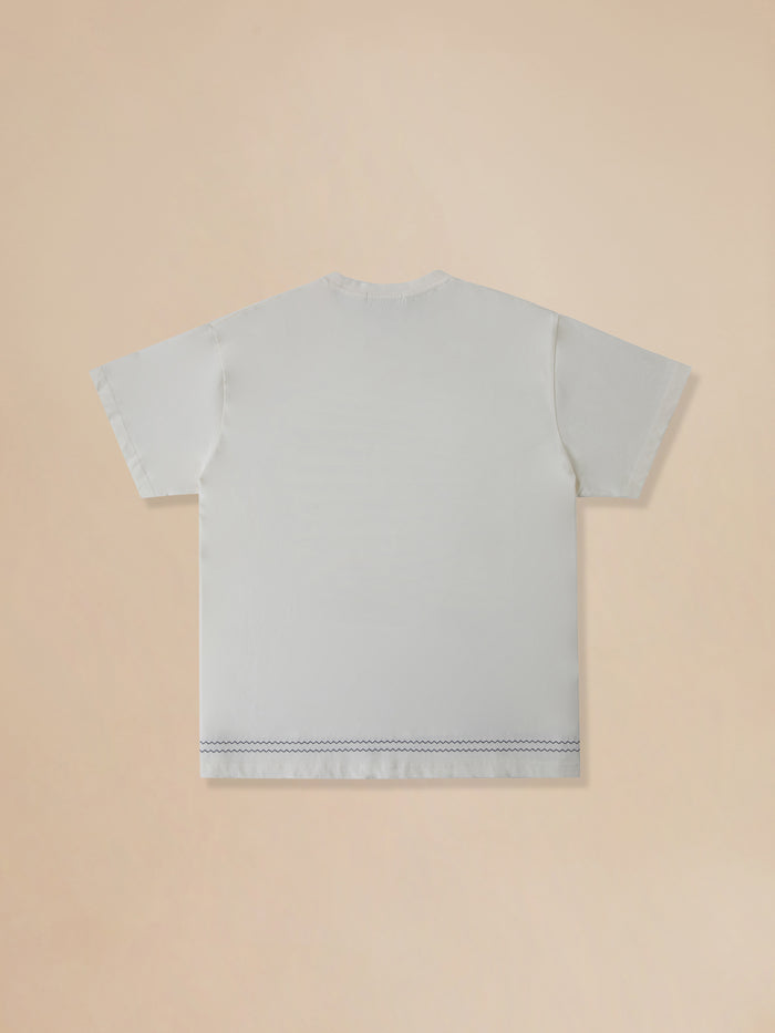 The back of a Found Bouquet Flowers Tee on a beige background.