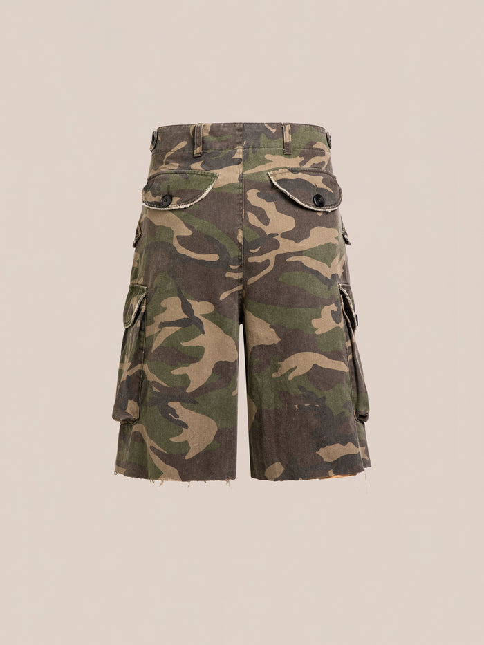 FOUND Camouflage Twill Utility Cargo Shorts feature a unisex relaxed fit, raw unfinished hems, and multiple pockets. Displayed on a plain beige background, they offer a true vintage-inspired look.