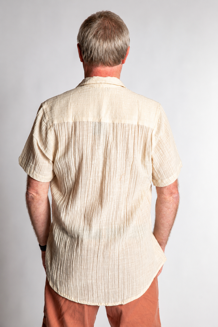 Chris, 5'7", wearing the Chandani Cotton Button Up in ivory white, size M