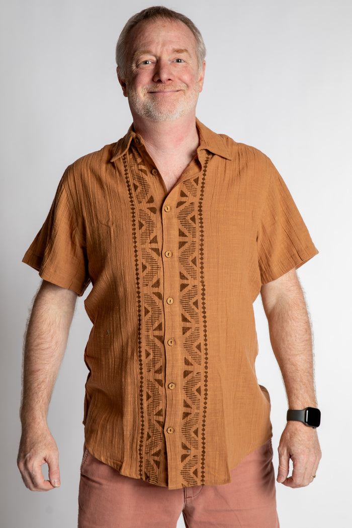 Chris, 5'7", wearing the Chandani Cotton Button Up in orange brown, size M
