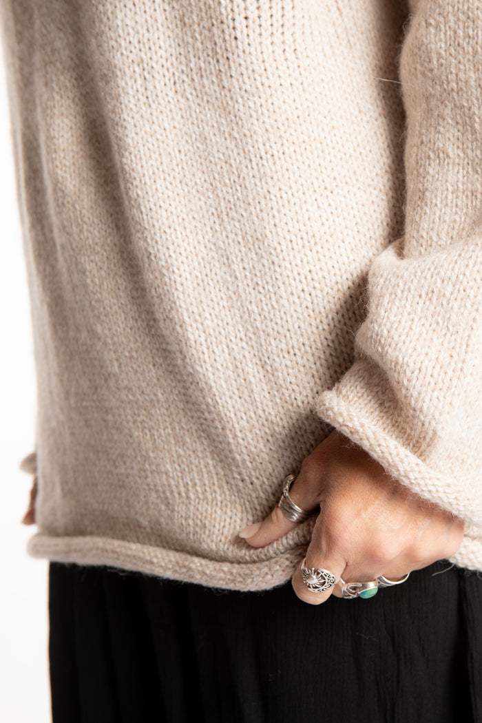 Jen wearing a size large oatmeal fisherman style sweater