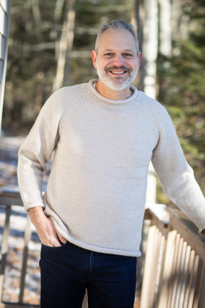 Michael is wearing size L roll neck alpaca sweater in oatmeal