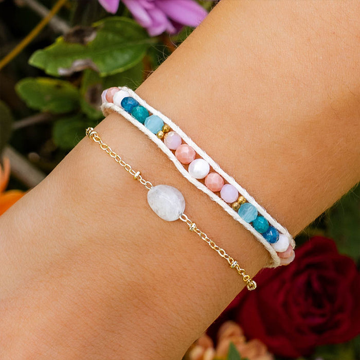 Coral Kiss Healing Bracelet, on wrist with flowers