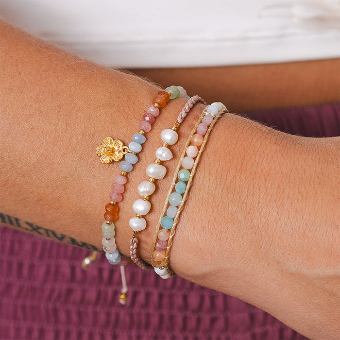 Coral Mermaids Pearl Bracelet, wrist stack against maroon