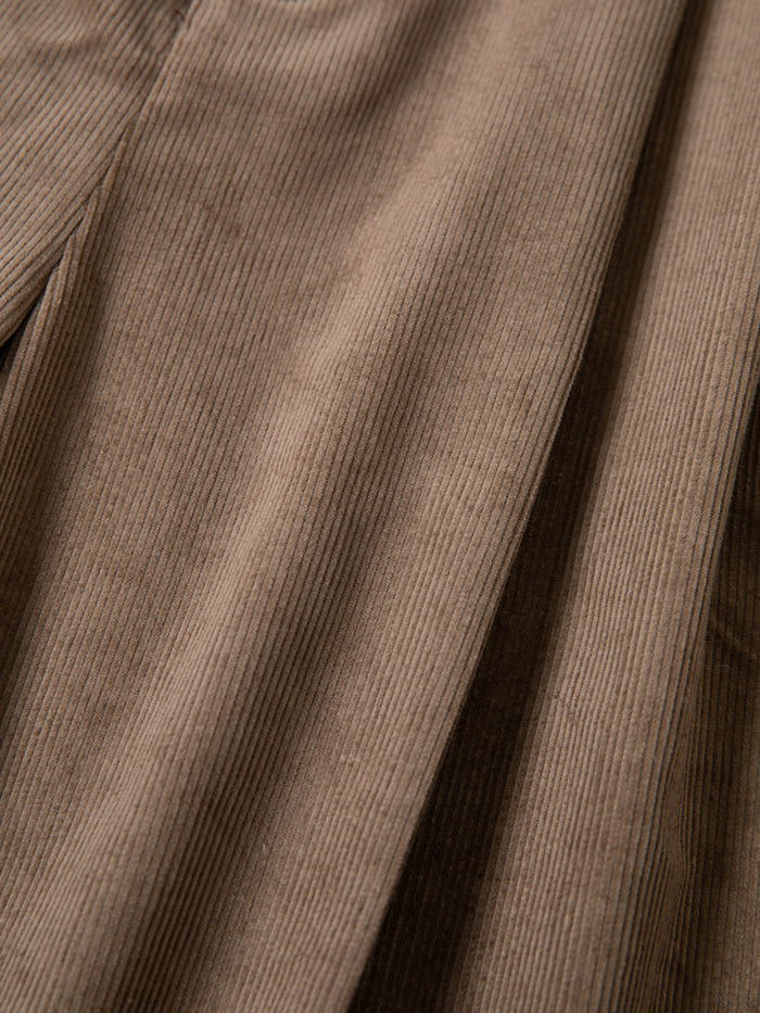 Close-up of FOUND Corduroy Pleated Trouser Shorts, showcasing their light brown color, signature vertical ridges, and relaxed unisex fit.