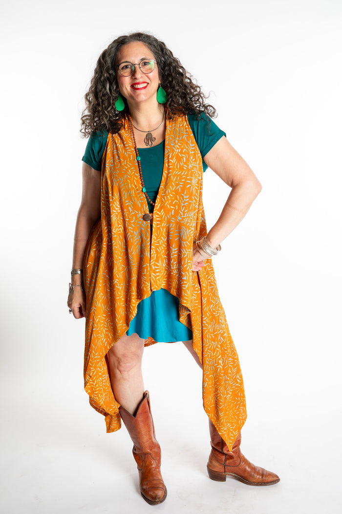 Susan wearing a long orange batik patterned vest in turmeric