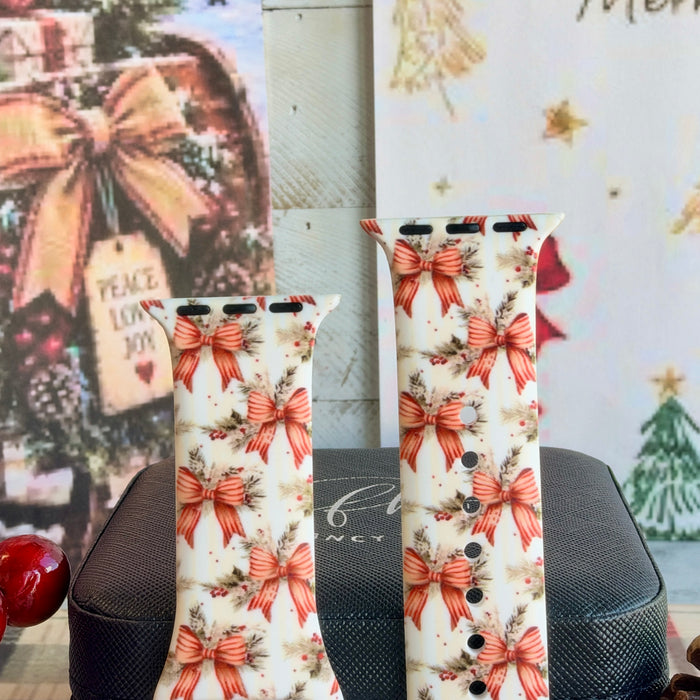Close-up of both Deck The Halls With Bows & Holly Apple Watch band straps with striped red ribbon bows, pine and holly berries