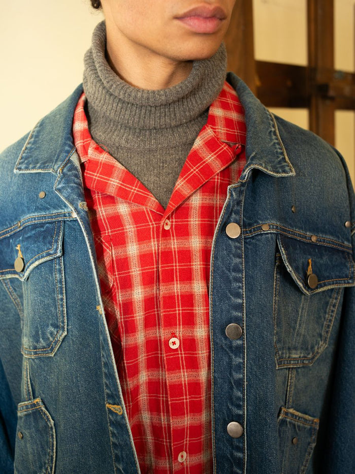 Showcasing a unisex relaxed fit ensemble with a gray turtleneck under a red plaid shirt and FOUND's Denim Carpenter Jacket, highlighting the timeless appeal of this workwear staple.