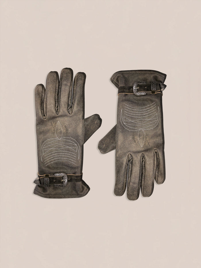 The Distressed Leather Western Gloves by FOUND, featuring decorative stitching and buckle details in brown leather, are displayed on a light background.