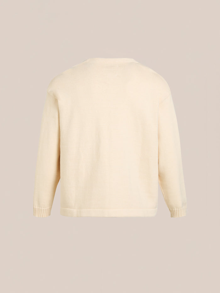 Back view of a plain cream-colored unisex Double Breasted Knit Cardigan by FOUND, featuring long sleeves and a simple design against a neutral background, crafted from a soft cotton blend.