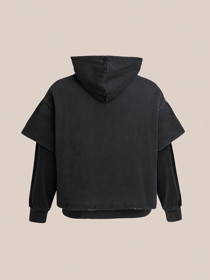 The Double Layer Hoodie by Found is a black hoodie with a vintage look, featuring layered sleeves and displayed against a plain background.