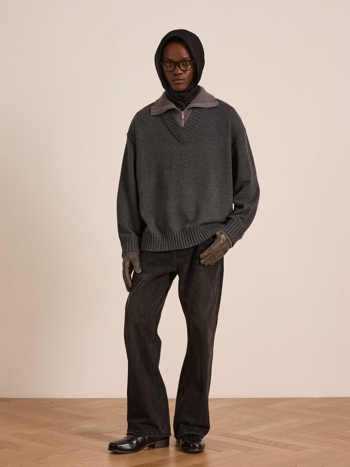 A person wearing a dark hood, glasses, FOUND's Double Layer Sweater over a high-collar shirt, dark gloves, wide-leg black jeans, and black shoes stands against a plain background—ideal for cold-weather layering.