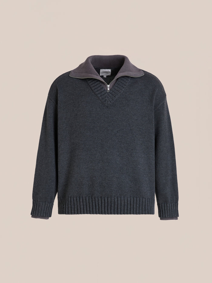 The FOUND Double Layer Sweater is a charcoal wool blend V-neck knit featuring a ribbed neckline, short front zipper, and ribbed cuffs and hem, shown against a plain beige background.