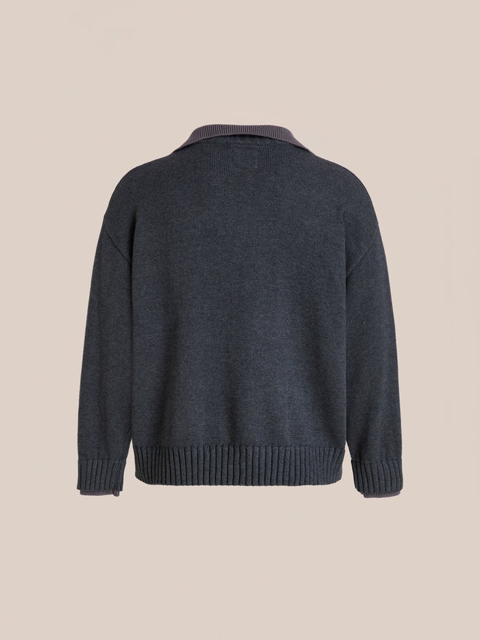 The FOUND Double Layer Sweater in charcoal wool blend is shown from the back with ribbed V-neck, cuffs, and hem, displayed on a plain beige background.