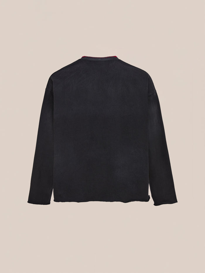 The FOUND Embroidered Patches LS Tee in vintage washed black is shown laid flat on a light beige background, displaying the back view.