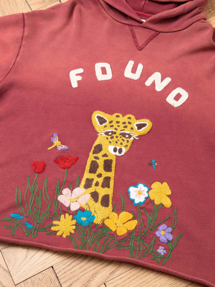 The FOUND Embroidered Wildlife Hoodie features a maroon color with "FOUND" above an embroidered giraffe, flowers, butterfly, and bee on the front. Made from Vintage French-terry Cotton for comfort and style.
