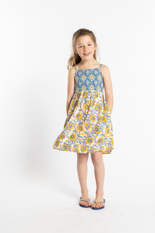 Louisa is wearing the size M sunflower floral kids dress with smocked back