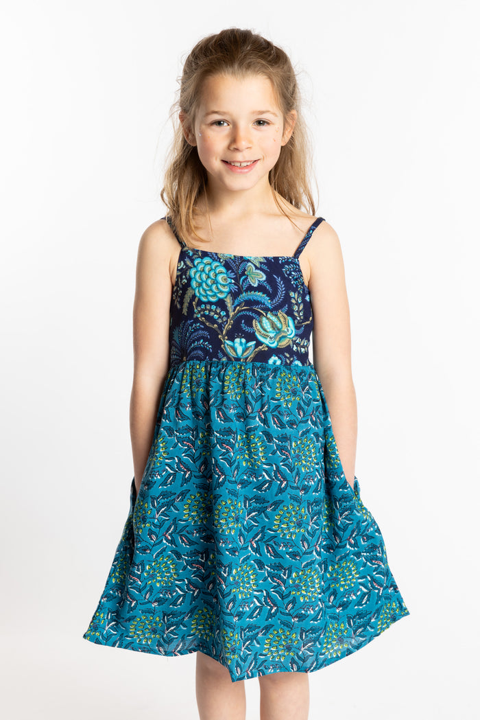 Louisa is wearing the size M teal floral kids dress with smocked back