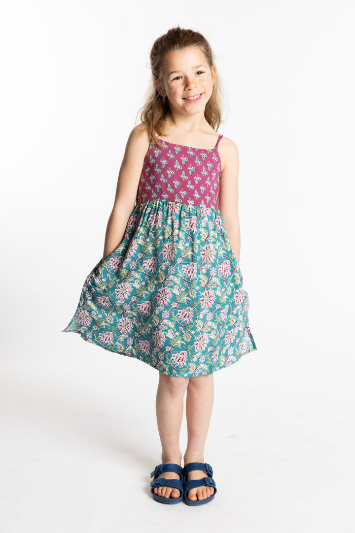 Louisa is wearing the size M Aqua floral kids dress with smocked back