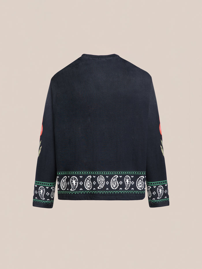 The FOUND Garden Bloom Embroidered LS Tee is a black long-sleeve with a relaxed fit, white and green patterned hem and cuffs, and red floral embroidery on the sleeves, shown from the back.