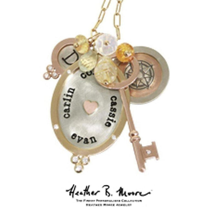 Rose gold necklace featuring personalized oval charm, gemstone accents, and key charms.
