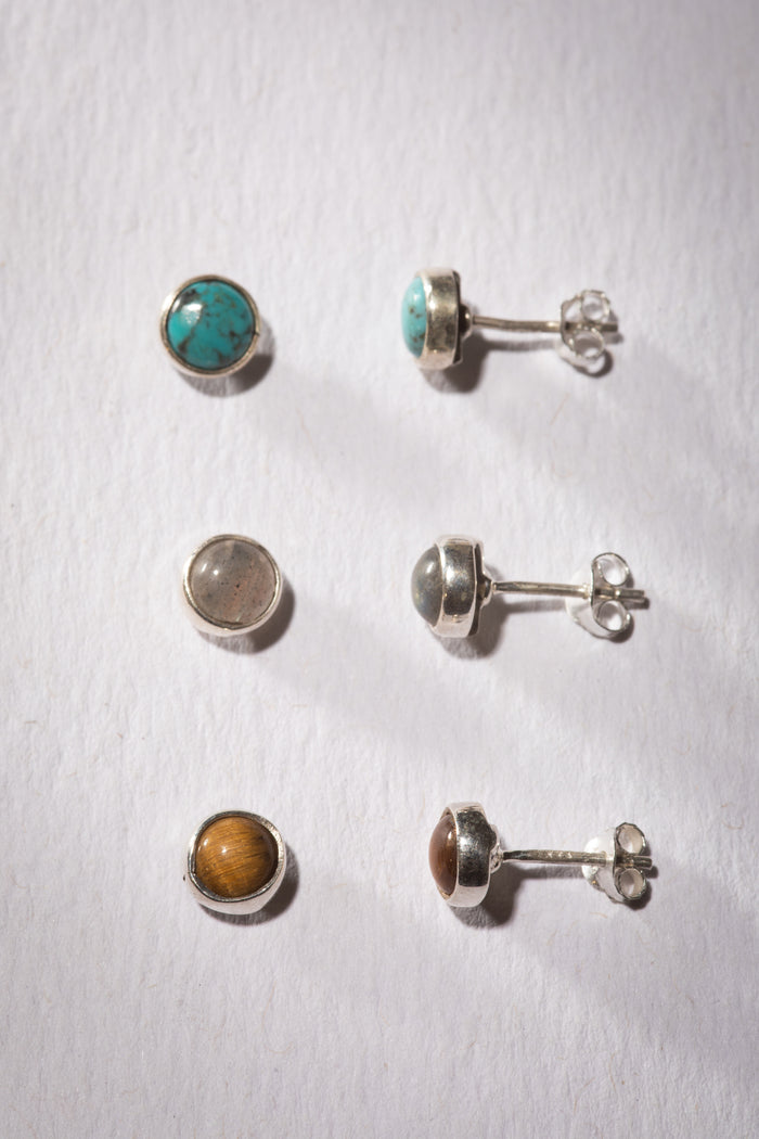 Gemstone earring stud trio in the theme of Grounding. The studs are Tiger Eye, Labradorite, and Turquoise