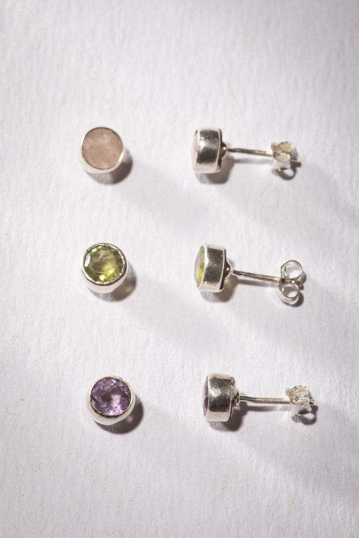 Gemstone earring stud trio in the theme of Compassion. The studs are Rose Quartz, Peridot, and Amethyst.