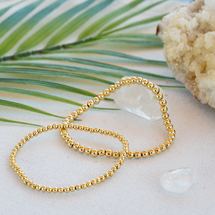 Gold 3mm Stretch Bead Bracelet, flat lay with crystal