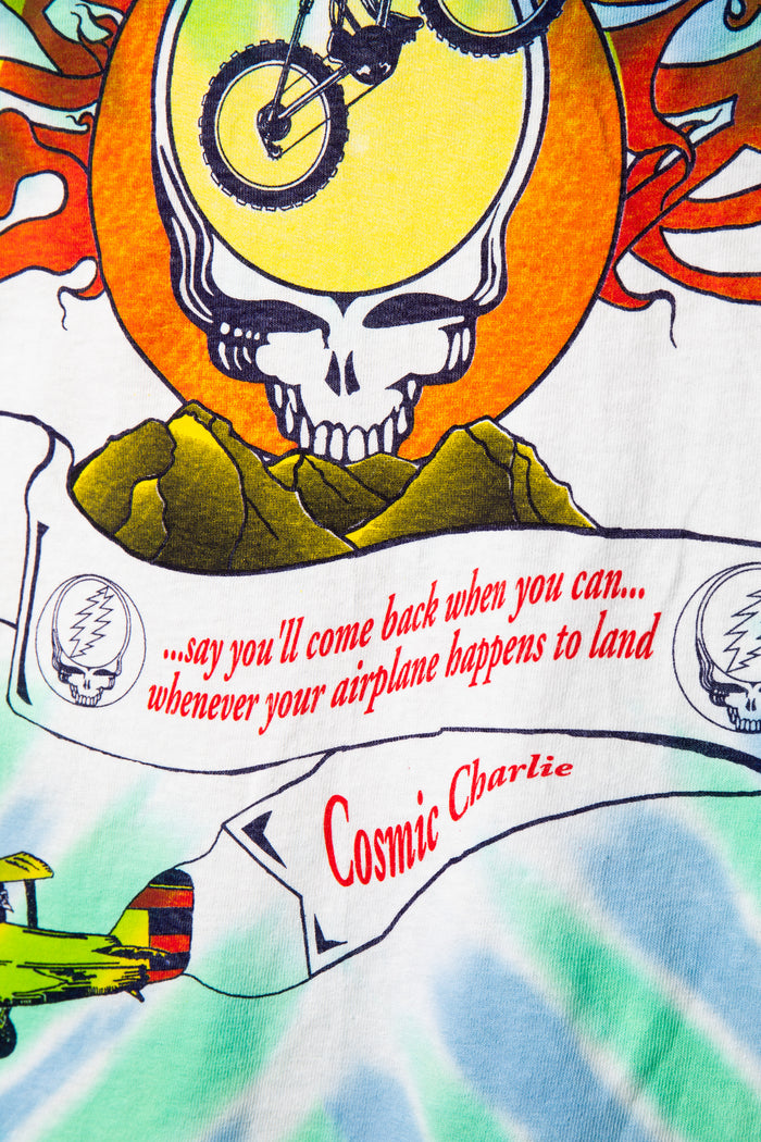 Colorful tie-dye shirt with a skull design, text, and airplane graphic.