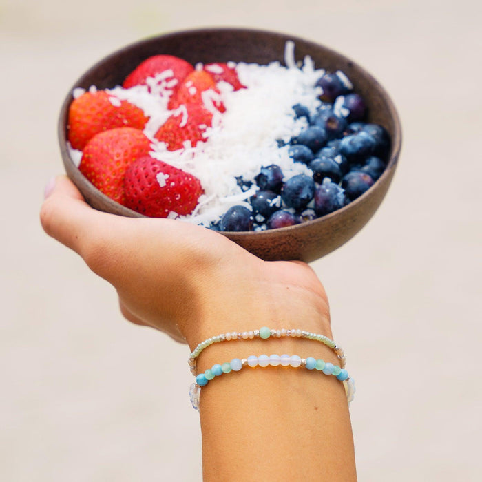 Intuition + Inner Peace 4mm Healing Bracelet, on wrist with a fruit bowl