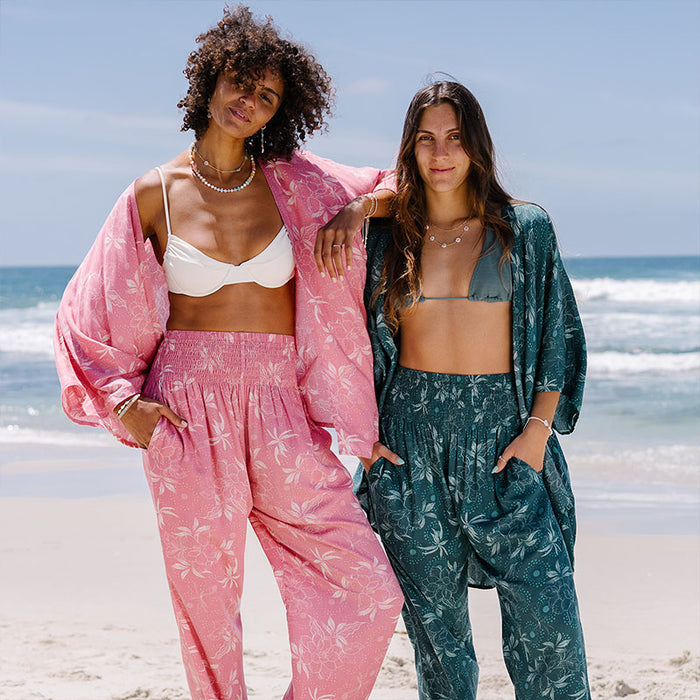 Jade Dahlia Harem Pants, worn with a second model on the beach