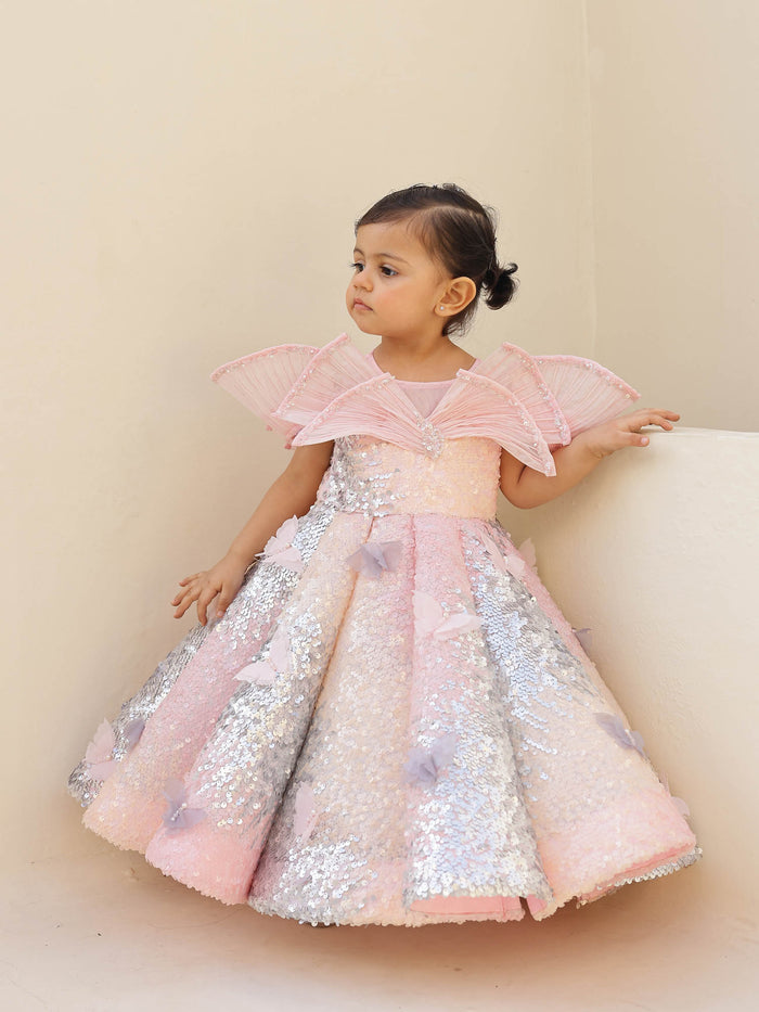 Luxury pink ombre sequin gown featuring a wired draped neckline, pearls, and butterflies‰ÛÓideal for first birthdays and party occasions.