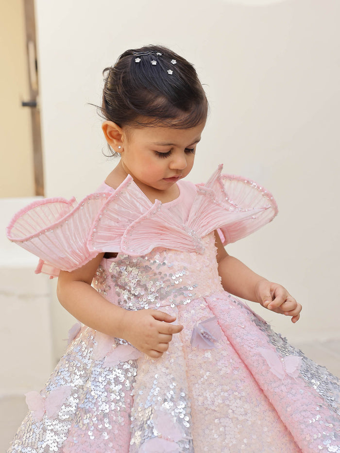 Elegant pink shimmer gown with shaded sequins, wired shoulders, and pearl accents‰ÛÓideal for first birthdays and premium occasions.