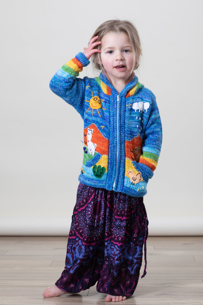 Aurora is wearing a kids nature scene sweater in blue